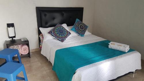 a bedroom with a bed and a blue chair at Villa Apolonia in Guaduas