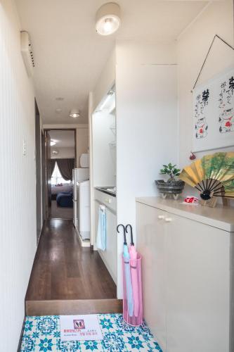 a small kitchen with a refrigerator and a counter at Cozy house 6, free wifi a rented electric bicycle in Kyoto