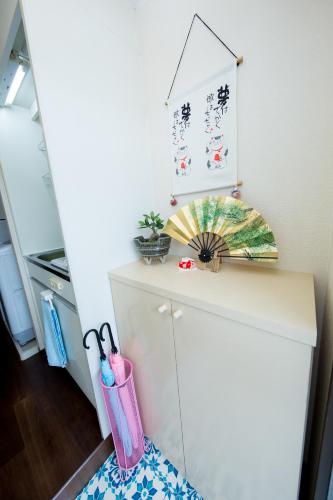 a white cabinet with a pink container on top of it at Cozy house 6, free wifi a rented electric bicycle in Kyoto