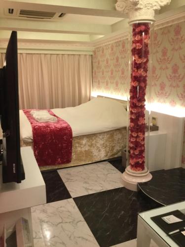 a small bedroom with a bed and a pillar at Hotel Regent (Adult Only) in Nagoya