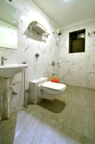 a white bathroom with a sink and a toilet at Hotel Dwarka Park in Shirdi