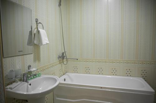 uma casa de banho com uma banheira e um lavatório em Hotel Minor em Samarkand