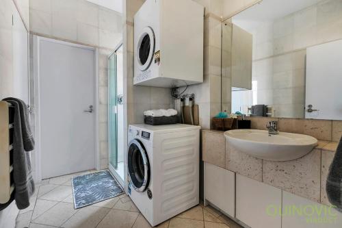 a bathroom with a washing machine and a sink at QV Downtown Executive Penthouse Parking Wifi - 782 in Auckland