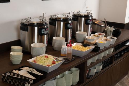 a buffet with plates and bowls of food on a table at The Celecton Tsuchiura Ekimae in Tsuchiura