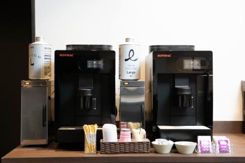 two coffee machines sitting on a counter with bowls at The Celecton Tsuchiura Ekimae in Tsuchiura