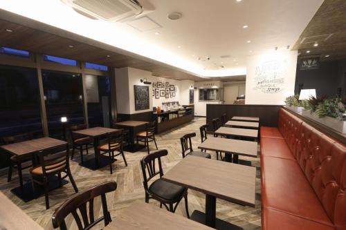 a restaurant with wooden tables and chairs and a bar at The Celecton Tsuchiura Ekimae in Tsuchiura
