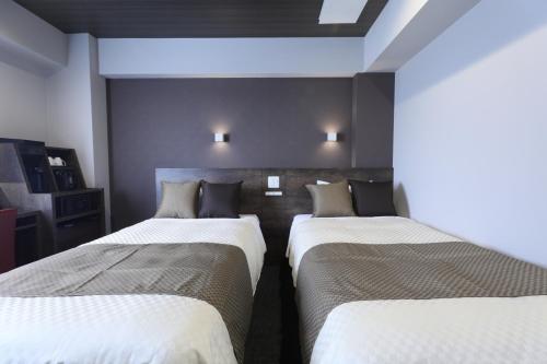a room with three beds in a room at The Celecton Tsuchiura Ekimae in Tsuchiura