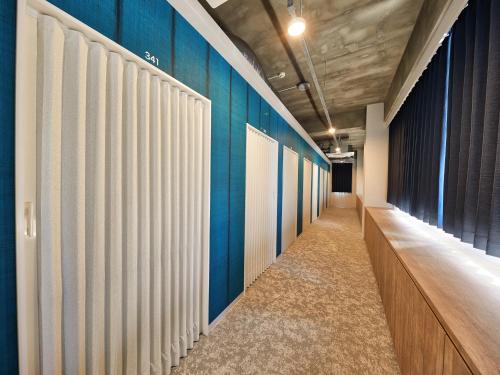 a hallway with blue and white partition walls at CABIN&HOTEL ReTIME in Naha