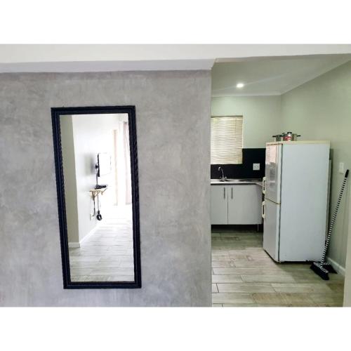 a mirror in a kitchen with a refrigerator at Waterfall Bed & Breakfast in Midrand