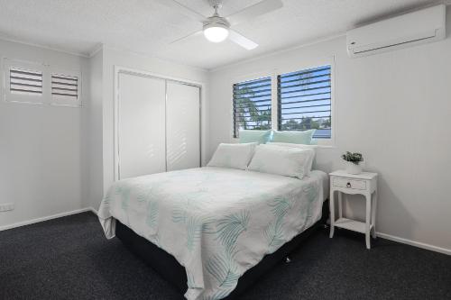 um quarto branco com uma cama e uma janela em Riverside location, Noosa Sound em Noosa Heads