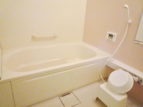a bathroom with a white tub and a toilet at Hotel Resort Inn Niseko in Niseko