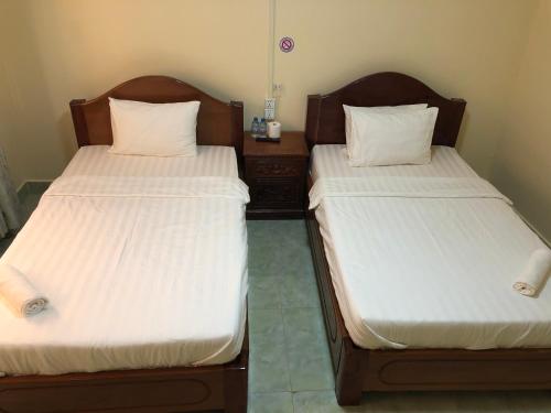 two beds sitting next to each other in a room at Savet Guesthouse in Stœ̆ng Trêng