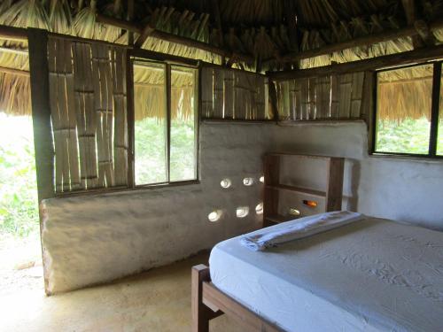 a bedroom with a bed in a room with windows at Reserva Atashi in La Poza