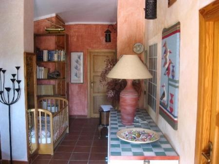 a hallway with a lamp and a table with a plate on the floor at Villa Asinara in Platamona