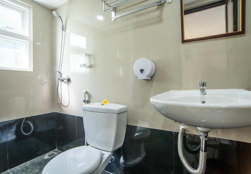 ein Badezimmer mit einer weißen Toilette und einem Waschbecken in der Unterkunft KELAN-TEL BALI in Jimbaran