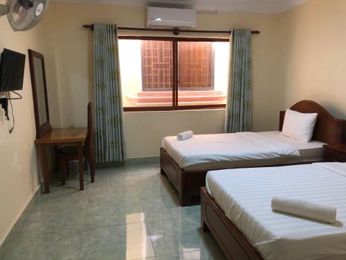 a hotel room with two beds and a window at Savet Guesthouse in Stœ̆ng Trêng