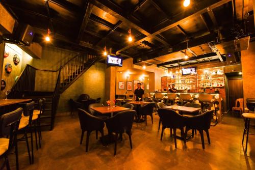 a restaurant with tables and chairs and a man standing in a room at Vivid A Boutique Hotel in Tiruchchirāppalli