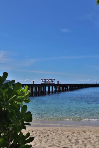 a pier in the water with a sandy beach at Shantaa Resort, Kohkood in Ko Kood
