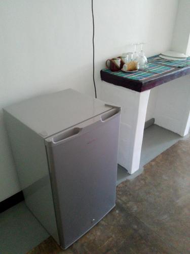 a small refrigerator in a kitchen with a counter at Villa Maleena in Hikkaduwa