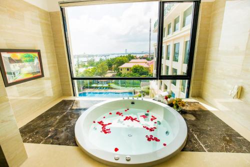 a bathroom with a large window and a bath tub at Muong Thanh Holiday Quang Binh Hotel in Dong Hoi