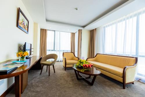 a living room with a couch and chairs and a table at Muong Thanh Holiday Quang Binh Hotel in Dong Hoi