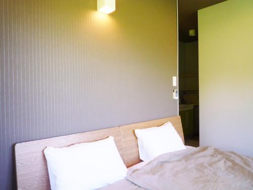 a bedroom with a bed with two white pillows at Hotel Resort Inn Niseko in Niseko