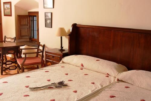 a bedroom with a bed with red roses on it at Palacio Viejo de Las Corchuelas in Torrejón el Rubio