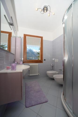 a bathroom with two sinks and a shower and two toilets at Lilli - Casa sul Lago in Dervio