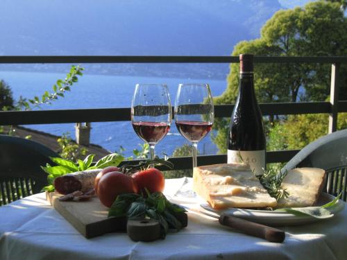 stół z dwoma kieliszkami wina i sera w obiekcie Lilli - Casa sul Lago w mieście Dervio