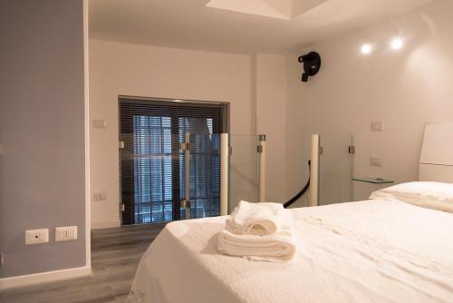 een witte slaapkamer met een bed en een raam bij YouHosty - Ariberto 22 in Milaan
