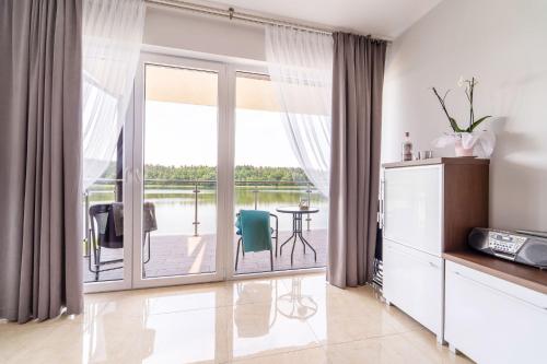 a living room with a sliding glass door with a balcony at Mazurskie Klimaty in Olsztyn