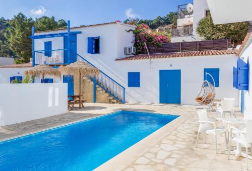 a villa with a swimming pool and blue and white buildings at ANTONIA STUDIOS in Voroklini
