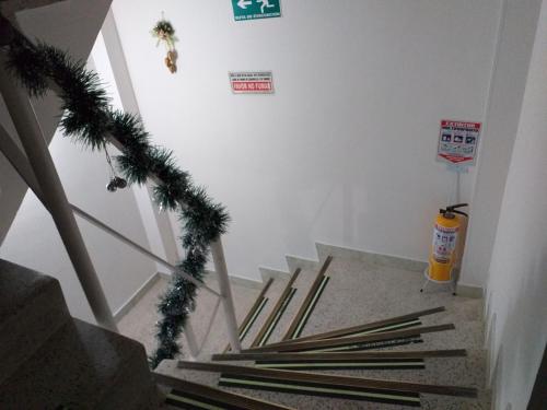 a hallway with stairs with christmas decorations and a fire extinguisher at Hotel Plata in Bogotá