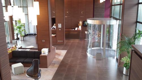 a lobby with a clock in the middle of a building at Best Western Plus Hotel Monza e Brianza Palace in Cinisello Balsamo