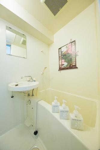 a white bathroom with a sink and a bath tub at Cozy house312 free wifi a rented electric bicycle in Kyoto