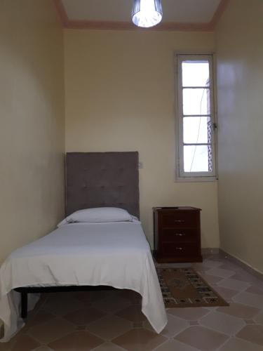 sypialnia z dużym łóżkiem i oknem w obiekcie Pension Safari w mieście Tanger