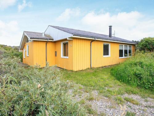 a yellow house on the side of a hill at 8 person holiday home in Hj rring in Hjørring