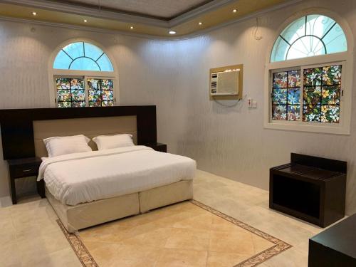 1 dormitorio con 1 cama grande y 2 ventanas en Masaken alkenan, en Yanbu