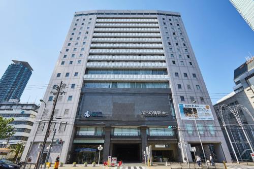 a tall white building in a city at Miyako City Osaka Tennoji in Osaka