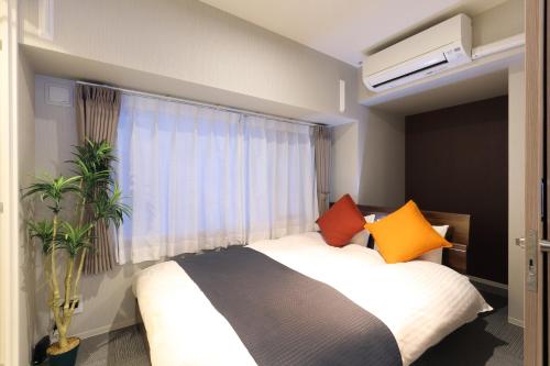 a bedroom with a bed and a window at Residence Hotel Hakata 19 in Fukuoka