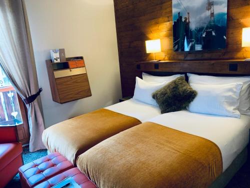 a hotel room with two beds and a chair at Coeur des Neiges in Saint-Gervais-les-Bains