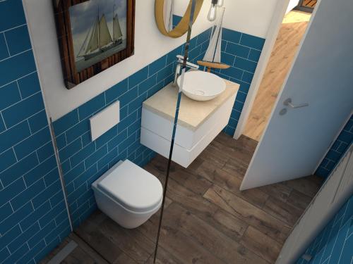 a blue bathroom with a toilet and a sink at Ferienhäuser Saalemaxx in Rudolstadt