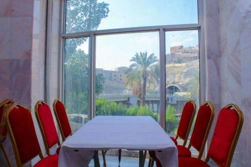 a table and chairs in a room with a window at Dar Al Bayan Hotel in Mecca