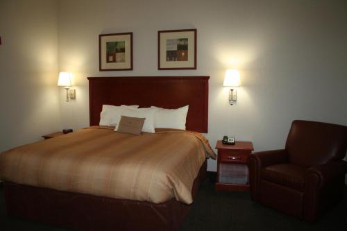 Habitación de hotel con cama y silla en Candlewood Suites Avondale-New Orleans, an IHG Hotel, en Avondale