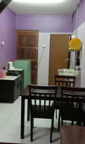 a kitchen with a table and chairs and purple walls at Bajet Homestay - low cost houses in Kuantan
