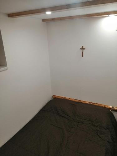 a room with a bed with a cross on the wall at László apartman in Harghita-Băi