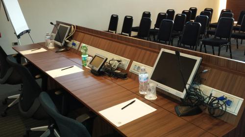 a conference room with a desk with a computer and chairs at Best Western Plus Hotel Monza e Brianza Palace in Cinisello Balsamo