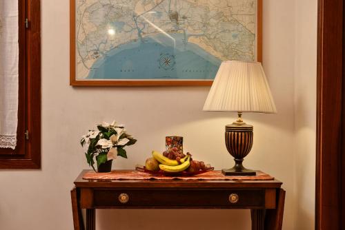 a table with a lamp and a bunch of bananas on it at Anzolo Palace - Rooms & Apartments in Venice