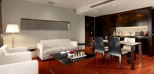 a living room with a couch and a table and chairs at Park Plaza London Westminster Bridge in London
