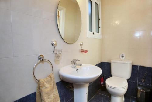 y baño con lavabo, aseo y espejo. en Villa in Universal, en Pafos